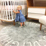 démonstration d'un bébé qui ce tien debout cur ce tapis rond lettre