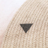 Petit triangle noir peint sur ce tapis rond jute