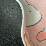 Photo du verso du tapis où on voit des points en caoutchouc antidérapant de ce tapis pour chambre bébé fille lapin