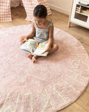 Mise en situation d'une jeune fille qui lit sur son tapis rose