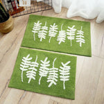 tapis de salle de bain vert avec des feuilles d'olivier blanche dessinée dessus 
