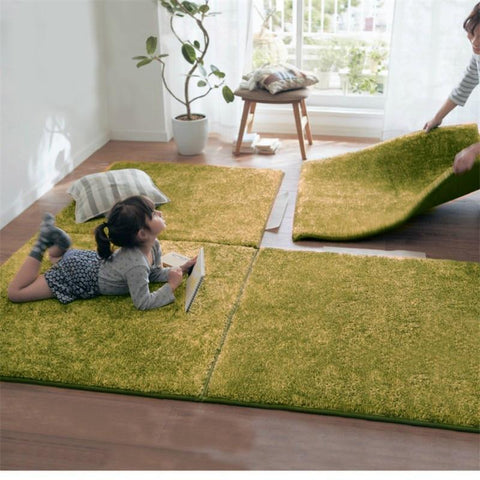 Mise en situation de ce tapis en morceaux ajoutable avec une petite fille allongée dessus 