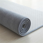 tapis de salon gris enrouler qui montre sous un autre angle ce fameux tapis de salon a la texture du velour