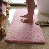 tapis de salle de bain rose avec 2 jambes de femme dessus 