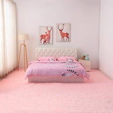 Chambre de fille principalement de couleur rose avec au centre de l'image un lit qui est posée sur un tapis de couleur rose claire